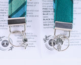 Two keychains with decorative elements on a printed background