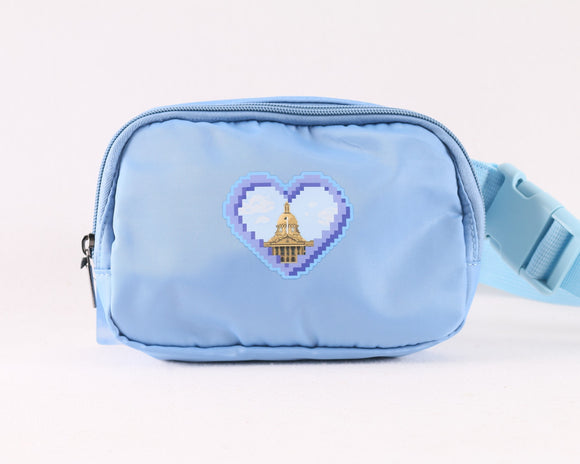 Light blue fanny pack featuring a pixelated heart design with the Alberta Legislature building at the center, displayed with adjustable strap and zippered main compartment