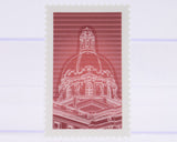 Red and white stamp with architectural design on a light purple background
