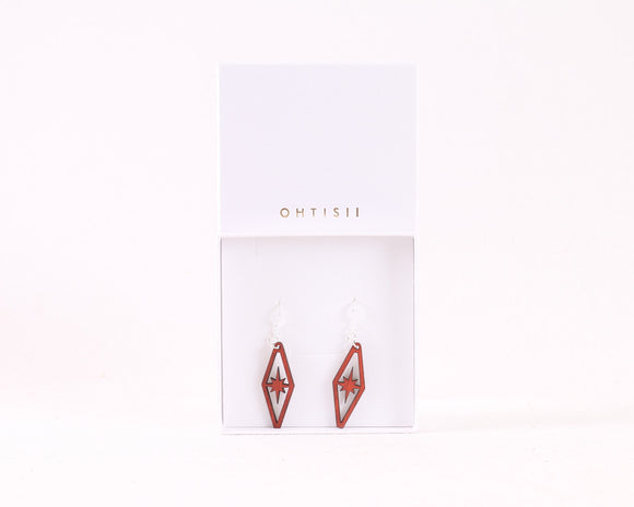 A pair of red wooden earrings shaped like a diamond with a starburst placed in the middle of the diamond. Comes with sterling silver fishhook earrings.