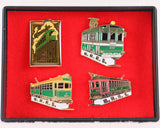 A red velvet box with 4 different enamel pins. All 4 pins feature a High-level Bridge streetcar